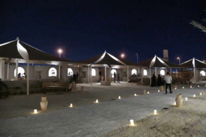Concert stage with vibrant lighting and large crowd in a dark indoor venue 