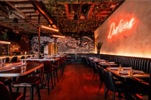 Modern restaurant interior with warm industrial lighting and nautical mural