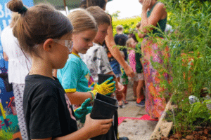 Children participating in a nature workshop, learning to plant and care for greenery with hands-on activities